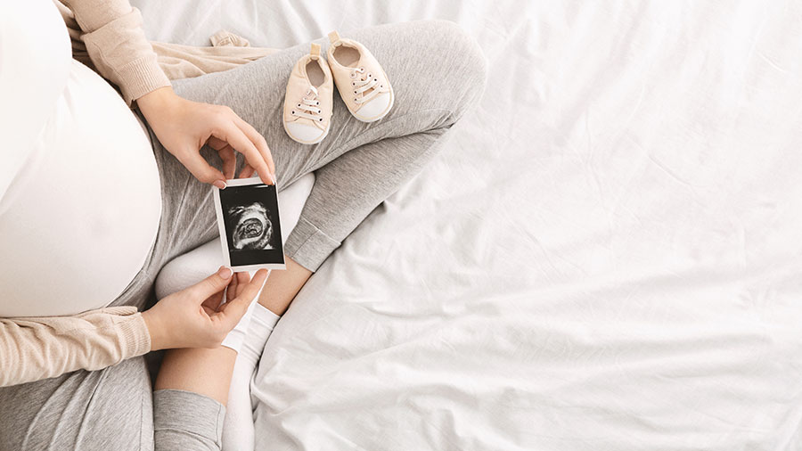 Expecting mother showing ultrasound scan photo